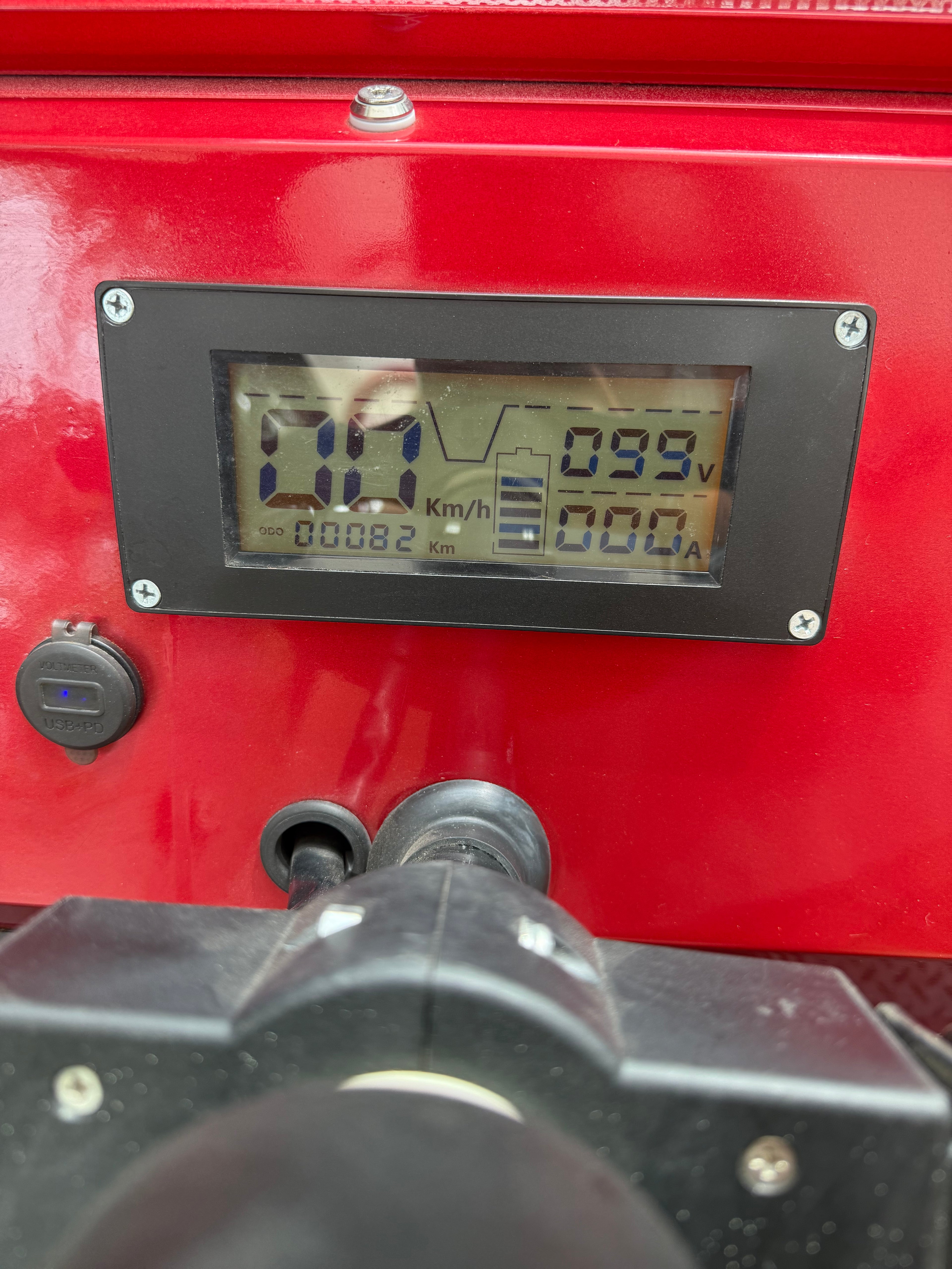 Digital display on a red vehicle with various readings.