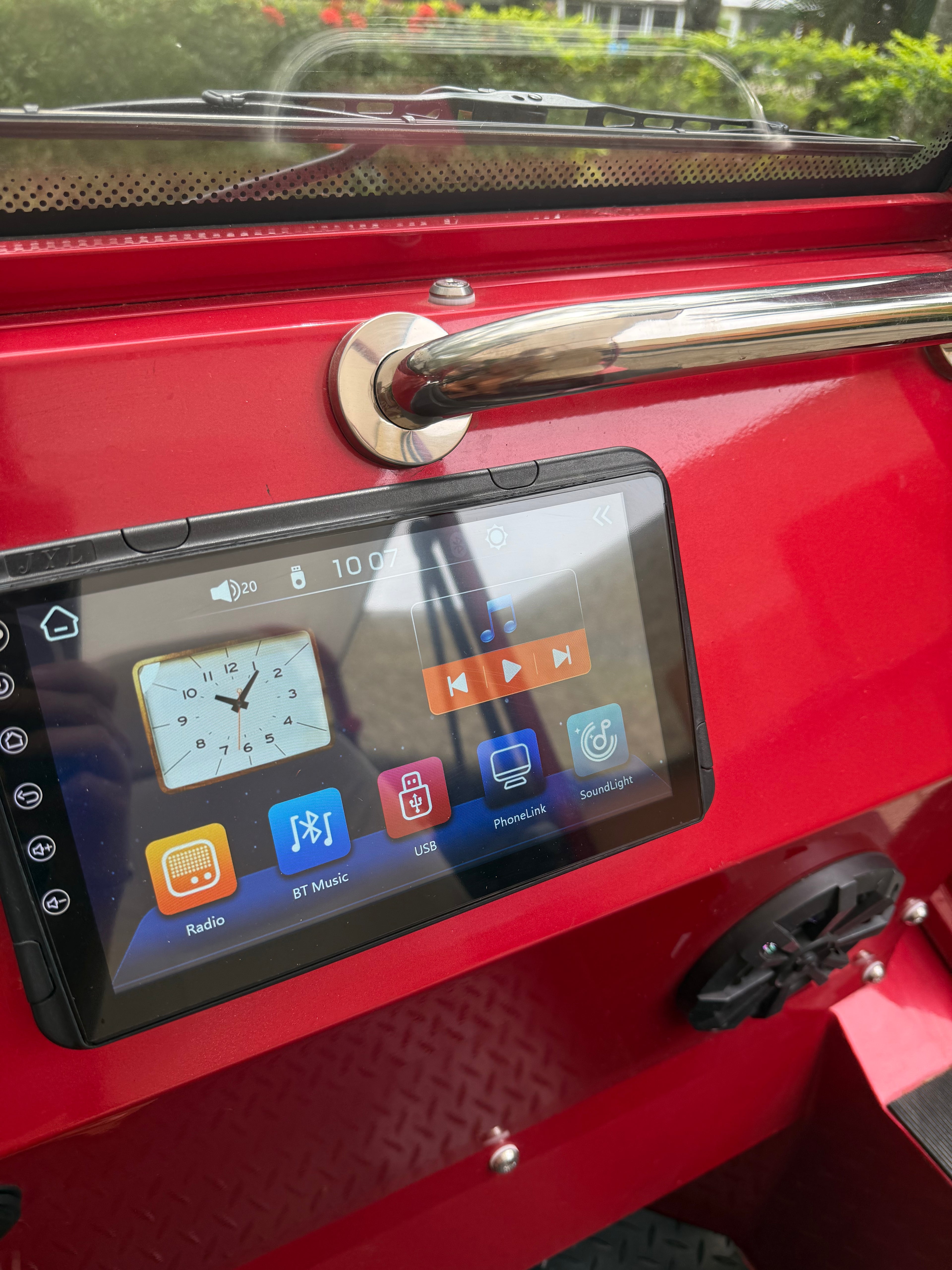 Digital display on a red vehicle with various icons and a clock.