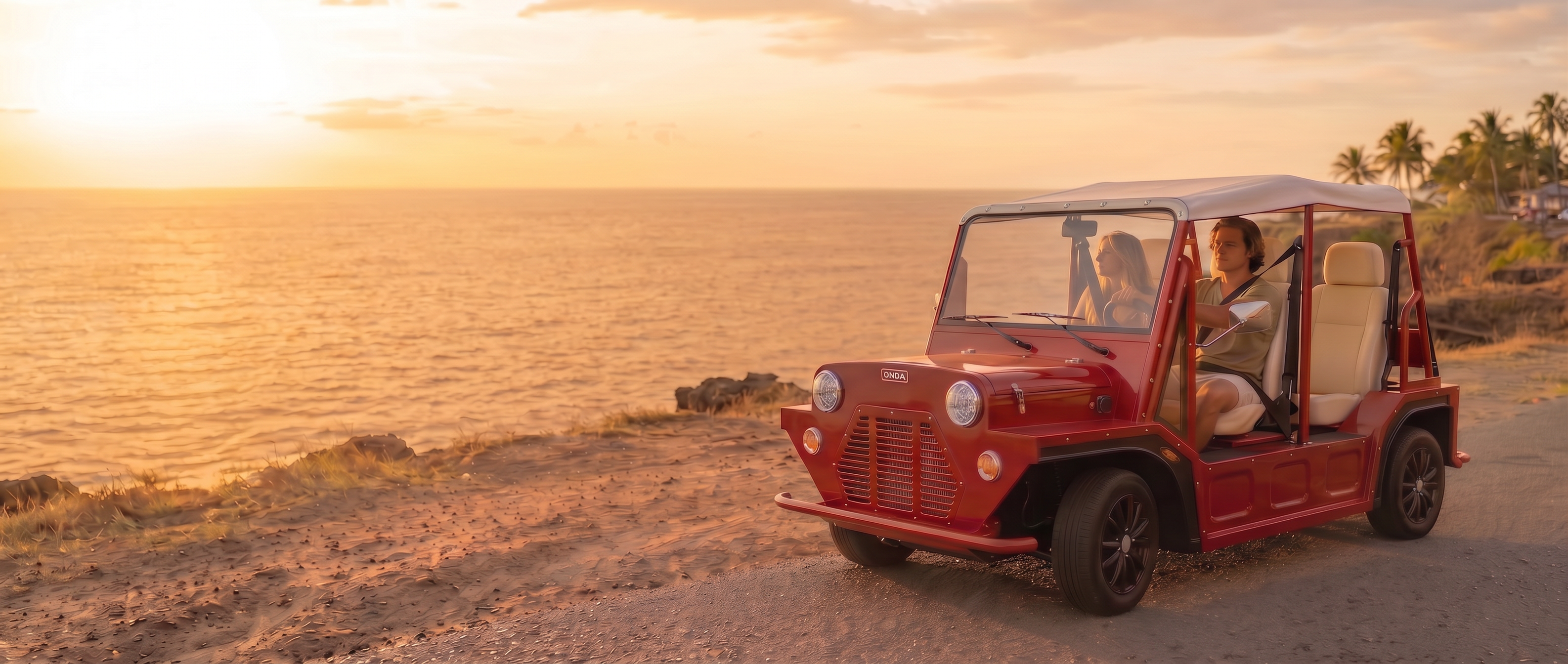 Red electric golf cart on a scenic road with ocean and sunset in the background